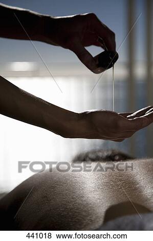 Close-up of a woman pouring oil onto her hands before massaging a man's back View Large Photo Image Stock Photo - Close-up of a woman pouring oil onto her hands before massaging a man's back. Fotosearch
