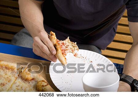 Stock Photo - Eating pizza in a university canteen. Fotosearch