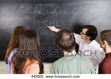 Lecturer writing on blackboard for a group of students View Large Photo Image Stock Photography - Lecturer writing on blackboard for a group of students. Fotosearch