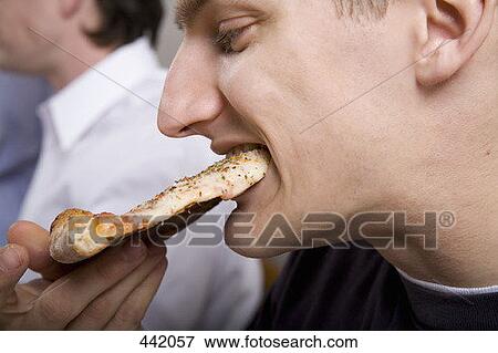 Man eating slice of pizza View Large Photo Image Stock Photo - Man eating slice of pizza. Fotosearch