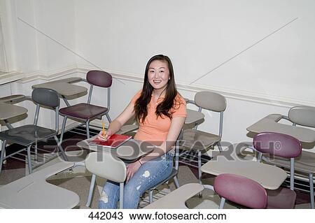 Stock Image - Student sitting in lecture room. Fotosearch