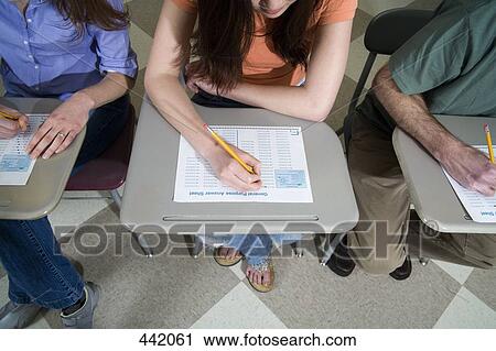 Students sitting at desks and writing View Large Photo Image Stock Image - Students sitting at desks and writing. Fotosearch