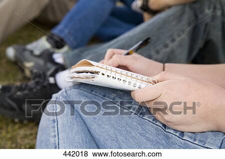 Students sitting on grass writing View Large Photo Image Stock Photo - Students sitting on grass writing. Fotosearch