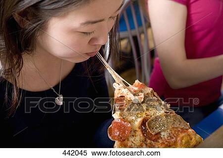 Woman eating slice of pizza View Large Photo Image Stock Photography - Woman eating slice of pizza. Fotosearch