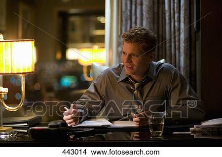 Businessman sitting at a desk and talking View Large Photo Image Picture - Businessman sitting at a desk and talking. Fotosearch