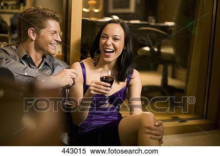 Young couple sitting together in a hotel room and drinking wine View Large Photo Image Stock Photography - Young couple sitting together in a hotel room and drinking wine. Fotosearch