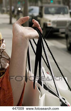 A woman holding shopping bags on a sidewalk, California, City of Los Angeles, USA View Large Photo Image Stock Photo - A woman holding shopping bags on a sidewalk, California, City of Los Angeles, USA. Fotosearch