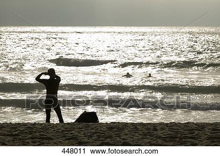 Silhouette of people at a beach View Large Photo Image Stock Image - Silhouette of people at a beach. Fotosearch