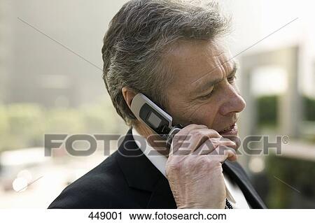 Stock Image - A businessman using a mobile phone. Fotosearch