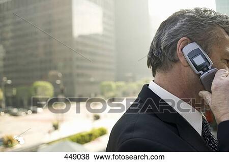 A businessman using a mobile phone View Large Photo Image Stock Photo - A businessman using a mobile phone. Fotosearch