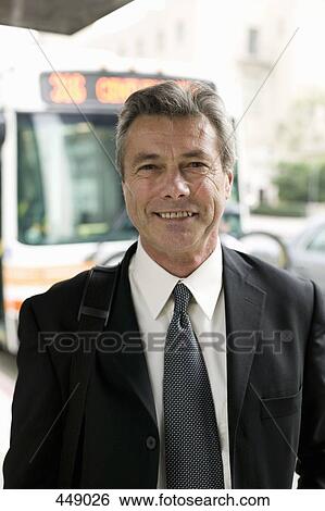 Stock Photograph - Businessman standing at a bus stop. Fotosearch