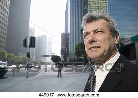 Businessman standing on a street corner View Large Photo Image Stock Photo - Businessman standing on a street corner. Fotosearch