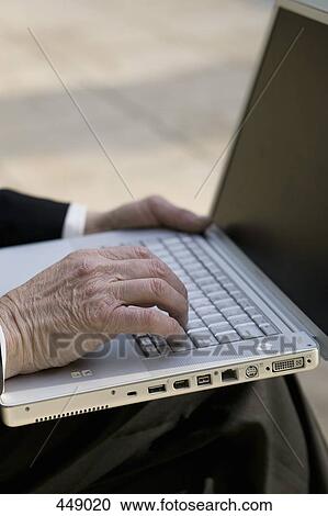 Close-up of a businessman using a laptop in a park View Large Photo Image Stock Image - Close-up of a businessman using a laptop in a park. Fotosearch