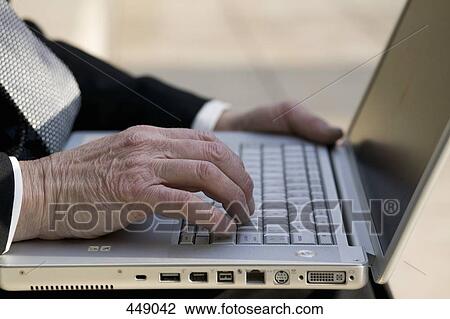 Close-up of a businessman using a laptop in a park View Large Photo Image Stock Image - Close-up of a businessman using a laptop in a park. Fotosearch