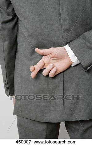 A man crossing his fingers behind his back View Large Photo Image Stock Photo - A man crossing his fingers behind his back. Fotosearch