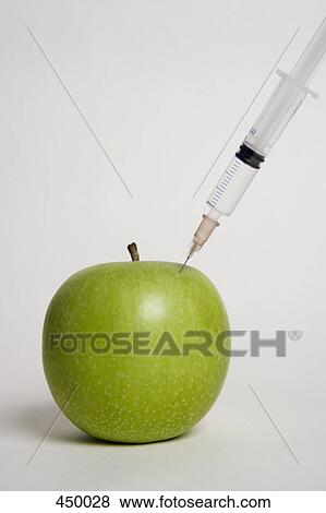 Stock Photo - A syringe injecting an apple. Fotosearch