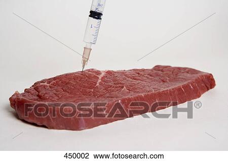 Stock Image - A syringe injecting meat. Fotosearch