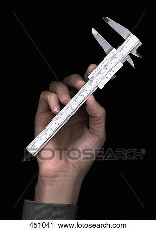 Man holding a caliper View Large Photo Image Stock Image - Man holding a caliper. Fotosearch