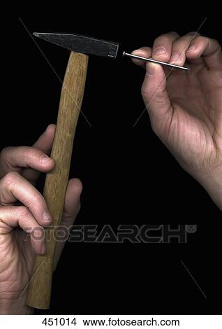 Man holding a hammer and a nail View Large Photo Image Picture - Man holding a hammer and a nail. Fotosearch