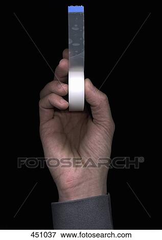 Man holding a roll of adhesive tape View Large Photo Image Stock Photo - Man holding a roll of adhesive tape. Fotosearch