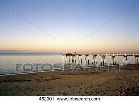 People standing at the edge of a pier at sunset View Large Photo Image Stock Image - People standing at the edge of a pier at sunset. Fotosearch