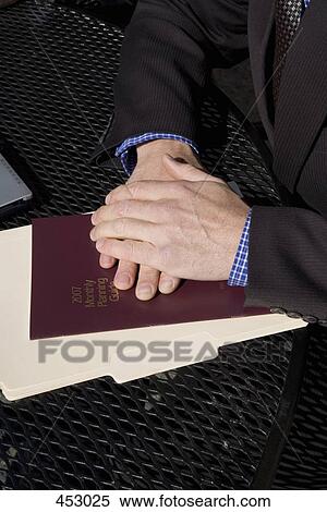 Businessman sitting at a table with files View Large Photo Image Stock Photography - Businessman sitting at a table with files . Fotosearch