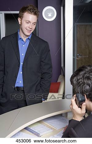 Businessman waiting at a reception desk View Large Photo Image Stock Photograph - Businessman waiting at a reception desk. Fotosearch