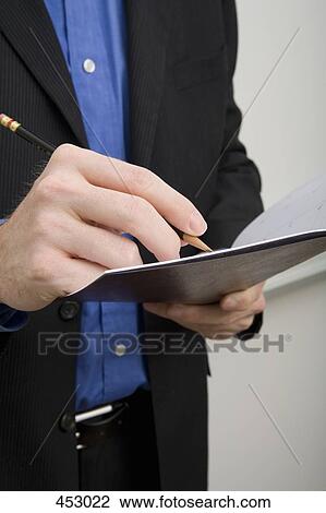 Businessman writing in a personal organizer View Large Photo Image Stock Image - Businessman writing in a personal organizer. Fotosearch