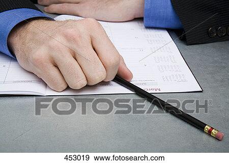 Close-up of a businessman at a desk with a personal organizer and a pencil View Large Photo Image Stock Photo - Close-up of a businessman at a desk with a personal organizer and a pencil. Fotosearch