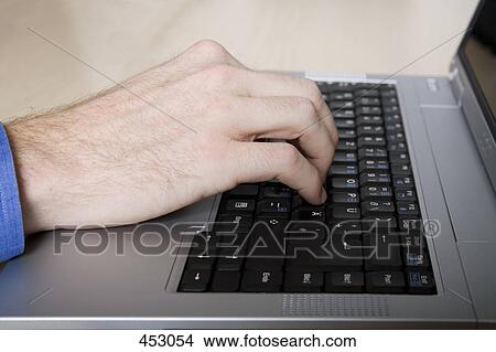 Close-up of a man typing on a laptop keyboard View Large Photo Image Picture - Close-up of a man typing on a laptop keyboard. Fotosearch
