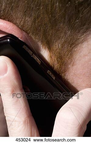 Close-up of a young man using a mobile phone View Large Photo Image Picture - Close-up of a young man using a mobile phone. Fotosearch