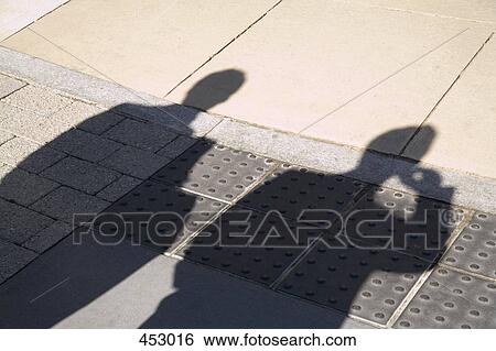 Shadow of two businessmen on the pavement View Large Photo Image Stock Photograph - Shadow of two businessmen on the pavement. Fotosearch