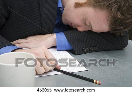 Young businessman asleep on a desk View Large Photo Image Stock Photography - Young businessman asleep on a desk. Fotosearch