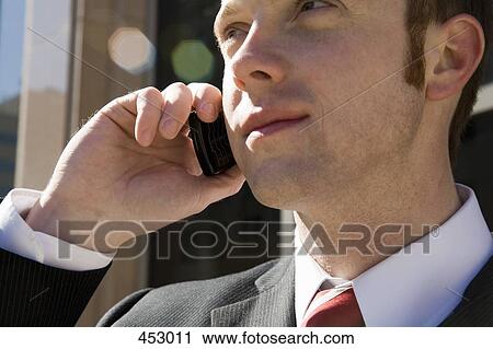 Young businessman using a mobile phone View Large Photo Image Stock Image - Young businessman using a mobile phone. Fotosearch