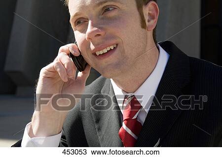 Young businessman using a mobile phone View Large Photo Image Stock Image - Young businessman using a mobile phone. Fotosearch