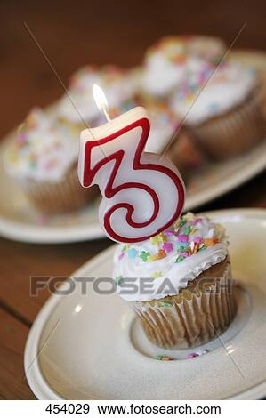 Stock Photo - Decorated cupcake with a lit candle. Fotosearch