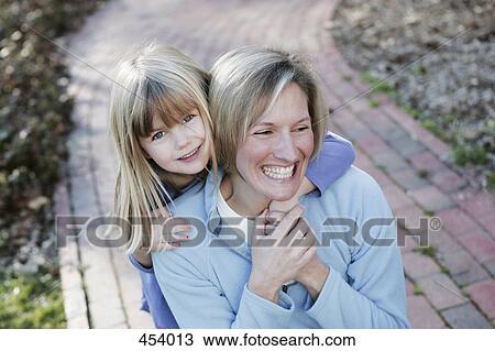 Mother and daughter embracing on a garden path View Large Photo Image Stock Image - Mother and daughter embracing on a garden path. Fotosearch