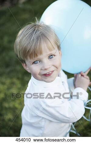Young boy holding a blue balloon View Large Photo Image Stock Image - Young boy holding a blue balloon. Fotosearch