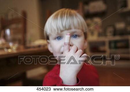 Stock Image - Young boy with an adhesive bandage on his finger. Fotosearch