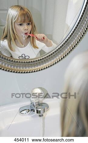 Young girl brushing her teeth in a bathroom View Large Photo Image Stock Image - Young girl brushing her teeth in a bathroom. Fotosearch