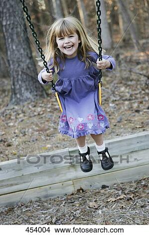 Young girl playing on a swing View Large Photo Image Picture - Young girl playing on a swing. Fotosearch