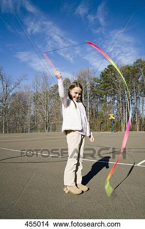 A girl holding a ribbon wand View Large Photo Image Picture - A girl holding a ribbon wand. Fotosearch