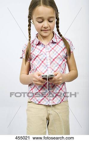 Stock Image - A girl listening to a MP3 Player. Fotosearch