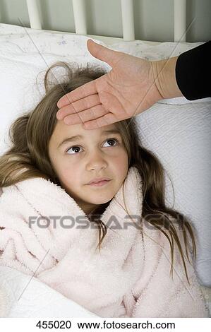 A girl lying in bed unwell View Large Photo Image Stock Image - A girl lying in bed unwell. Fotosearch