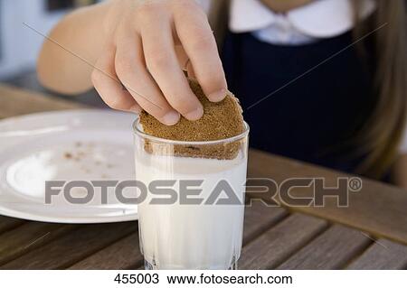 Child dipping a biscuit into a glass of milk View Large Photo Image Stock Image - Child dipping a biscuit into a glass of milk. Fotosearch