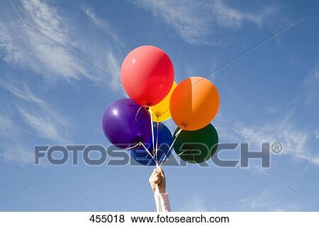 Hand holding helium balloons View Large Photo Image Stock Photo - Hand holding helium balloons. Fotosearch