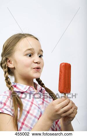 Young girl holding an ice lolly View Large Photo Image Stock Image - Young girl holding an ice lolly. Fotosearch