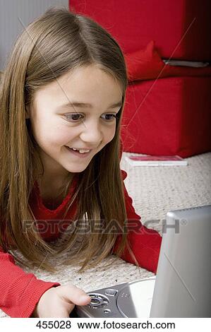 Young girl watching portable DVD player View Large Photo Image Stock Photo - Young girl watching portable DVD player. Fotosearch