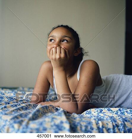 Girl lying on her bed View Large Photo Image Stock Image - Girl lying on her bed. Fotosearch