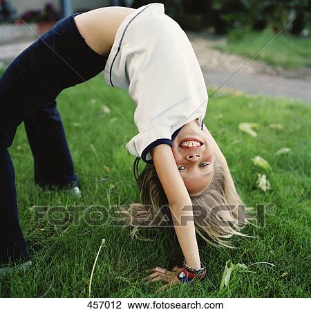 Girl practicing gymnastics in the garden View Large Photo Image Stock Image - Girl practicing gymnastics in the garden. Fotosearch